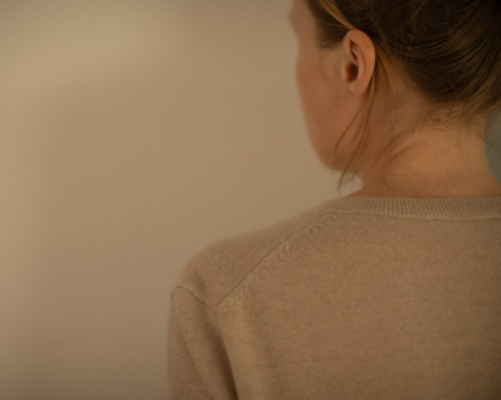 Minimal knitwear editorial portrait with soft disappearing silhouette by Anya Baro