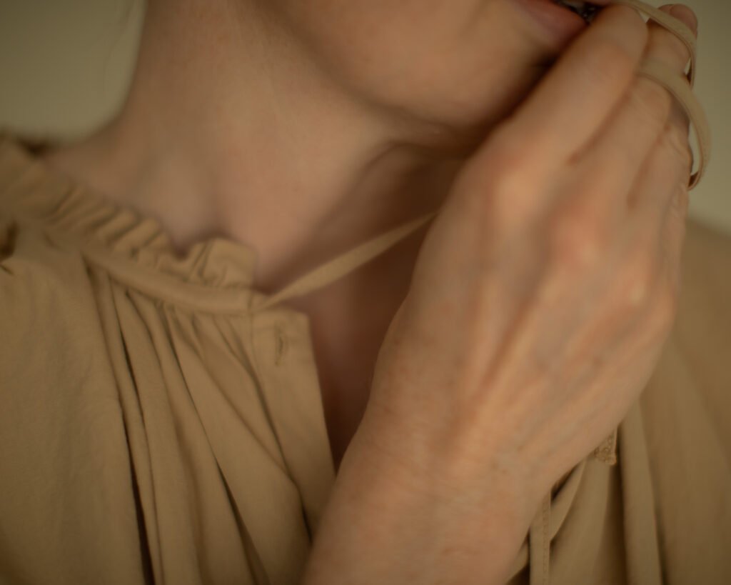 Hand gently holding a fabric ribbon in a moment of calm attention