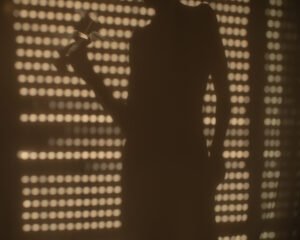Cinematic silhouette behind patterned warm light shadows