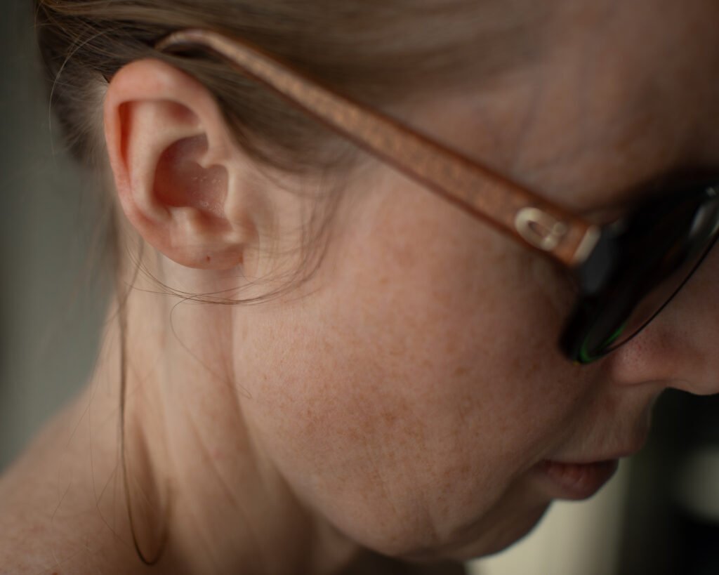 Anya Baro wearing luxury sunglasses in soft natural window light