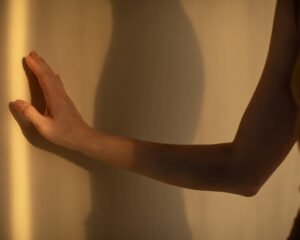 Hand touching shadow in warm golden cinematic light