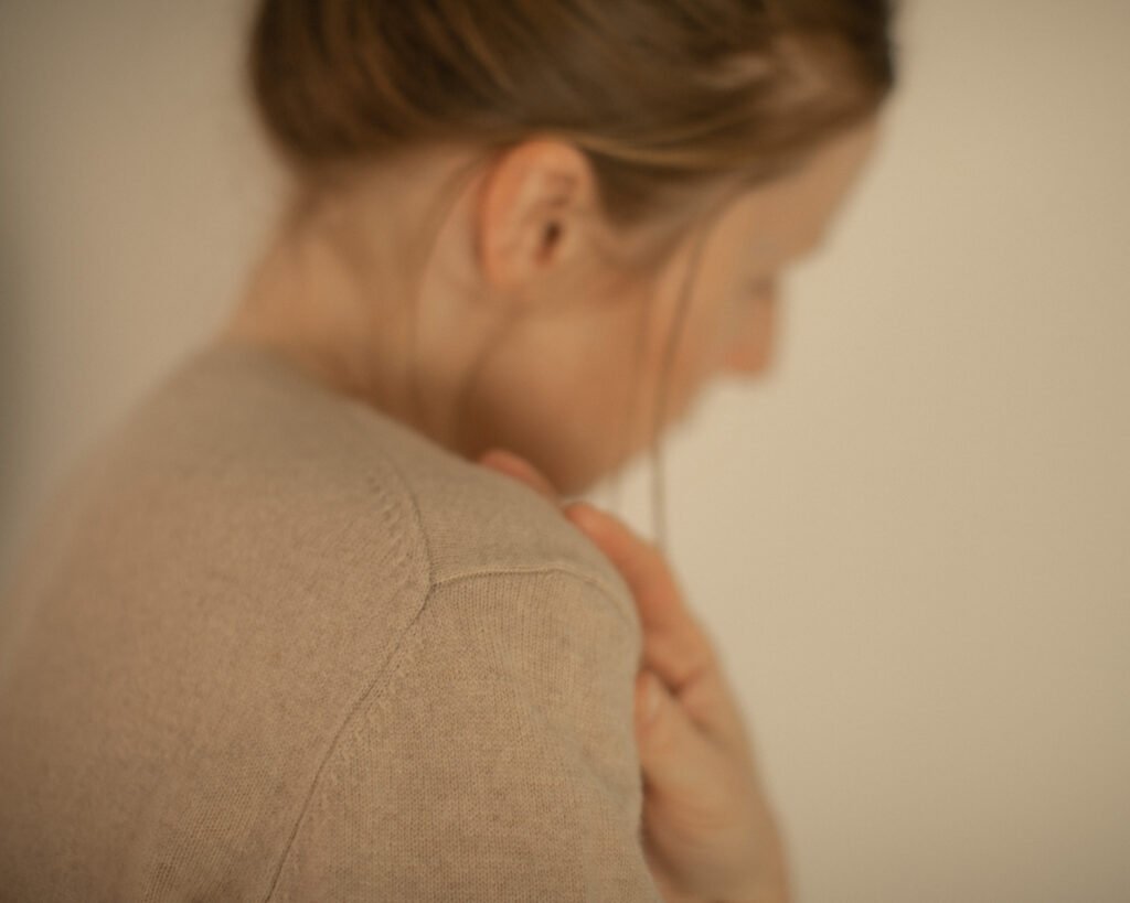 Woman in soft beige knitwear photographed in quiet luxury editorial style by Anya Baro