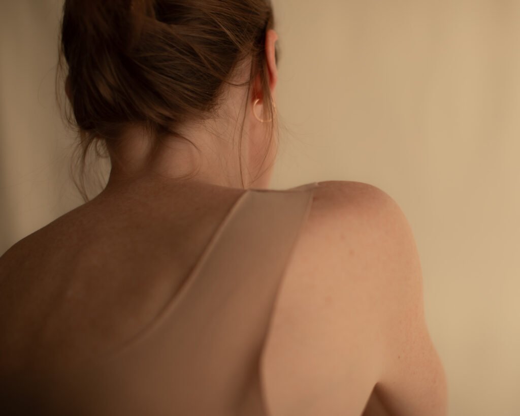 Quiet luxury skincare portrait with warm light and bare back