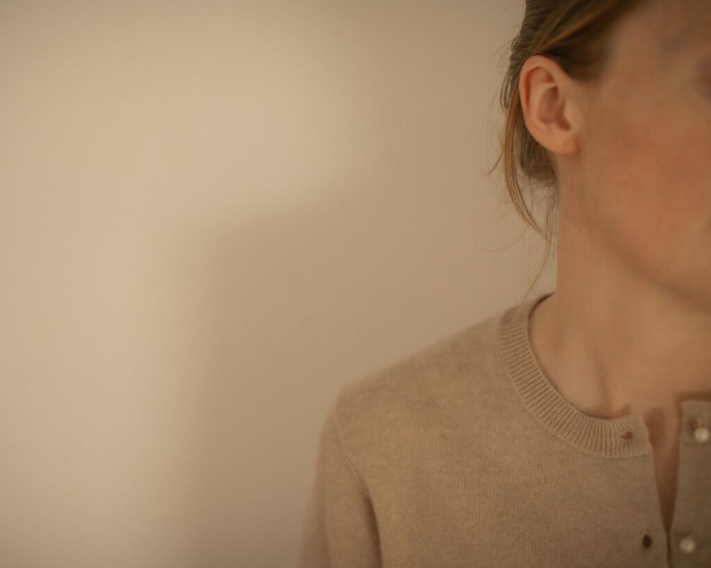Minimal knitwear portrait with negative space and soft warm light by Anya Baro