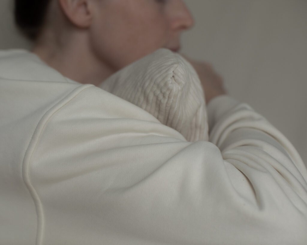 Quiet portrait embracing a textured cushion.